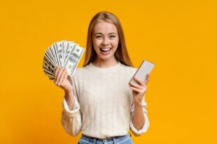 در تصویر دختری با یک دست پر از پول و دست دیگرش گوشی موبایل را نشان می‌دهد. در این مطلب اشاره می‌کنیم که می‌توان تنها با یک گوشی به کسب درآمد در فضای آنلاین پرداخت.