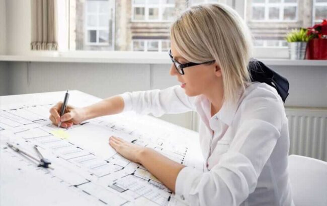 یک زن در حال انجام طراحی معماری است و او مهارت‌های ضروری برای معمار بودن را دارد تا در کارش موفق شود.
