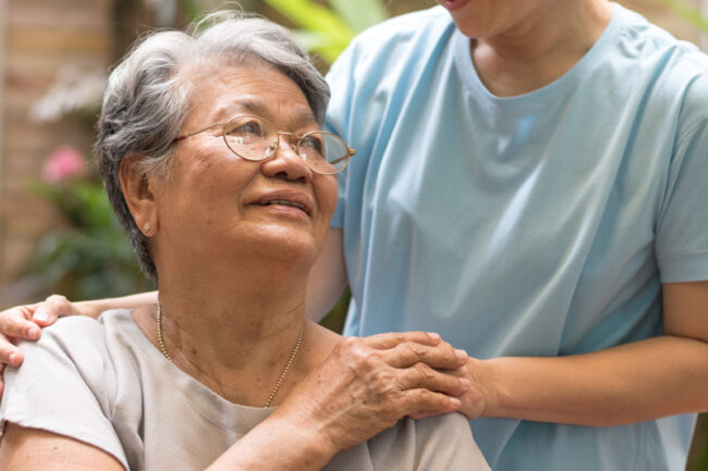 یک مراقب در حال کمک به یک فرد سالمند و ارائه خدمات مورد نیاز برای سالمندان به او است.